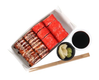 Food delivery. Paper box with different delicious sushi rolls near soy sauce, ginger, wasabi and chopsticks on white background, top view