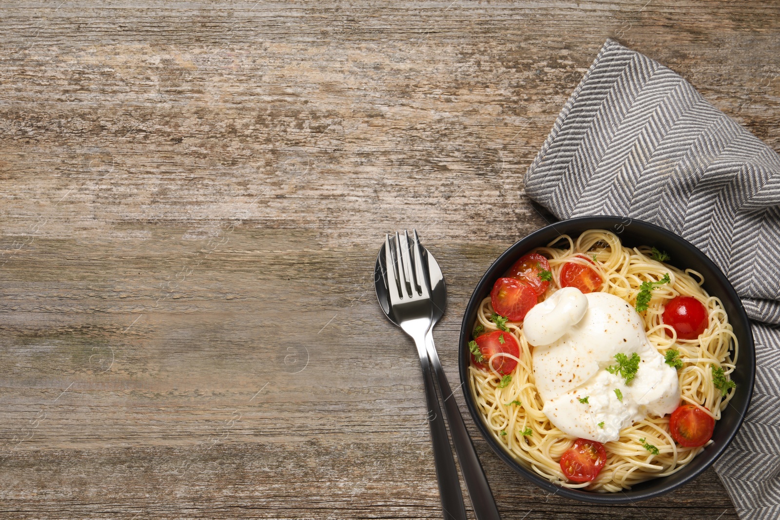 Photo of Delicious spaghetti with burrata cheese and tomatoes on wooden table, flat lay. Space for text