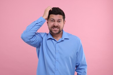 Photo of Portrait of embarrassed man on pink background