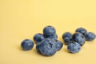 Tasty ripe blueberry on color background, closeup