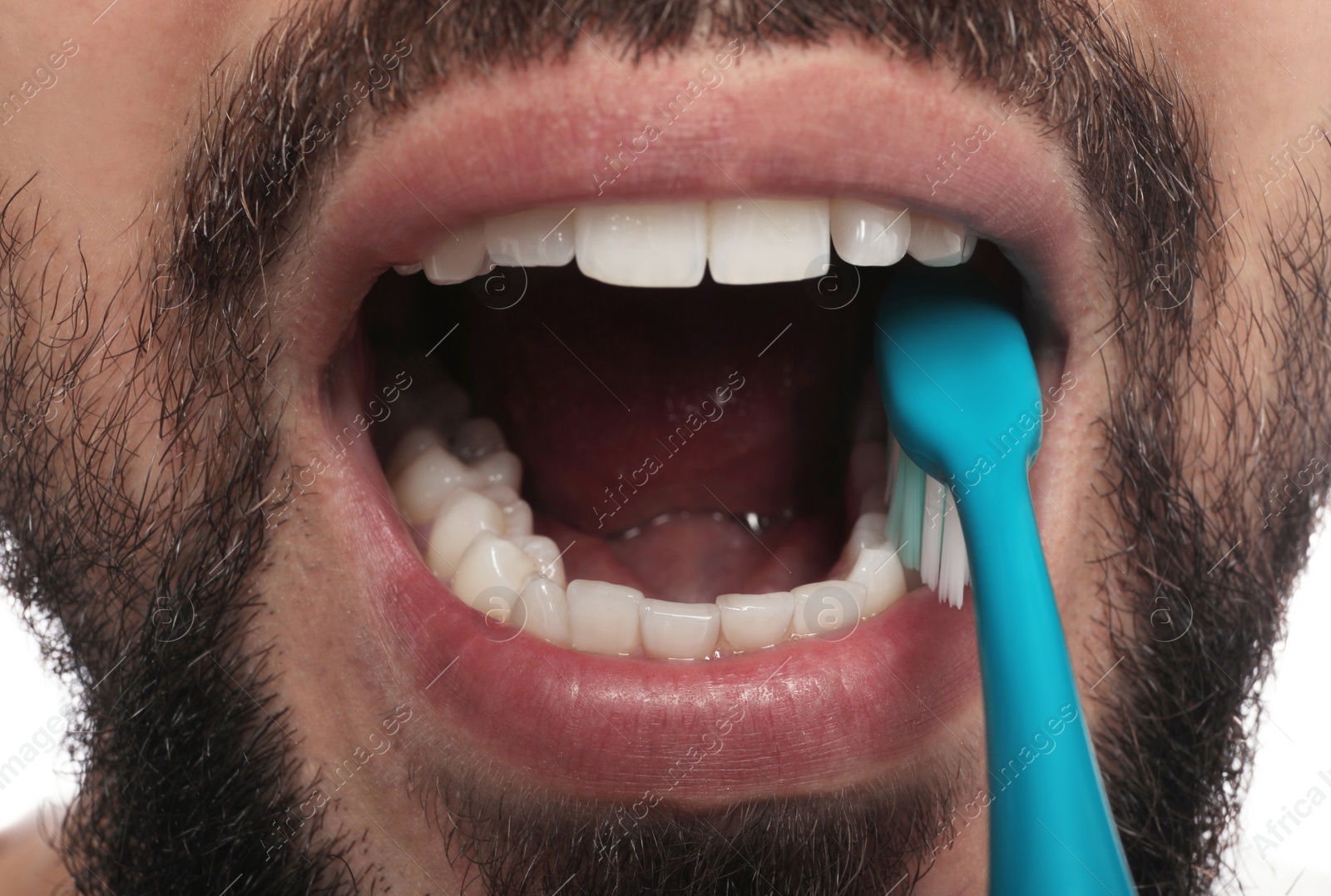 Photo of Man brushing teeth on white background, closeup. Dental care