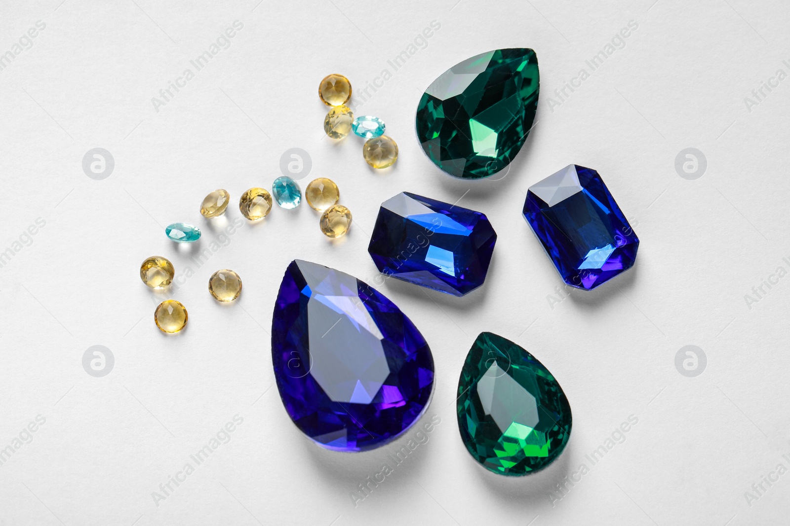 Photo of Different beautiful gemstones for jewelry on white background, flat lay