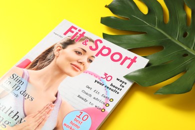 Photo of Sports magazine with green leaf on yellow background