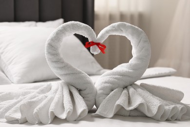 Photo of Honeymoon. Swans made of towels on bed in room