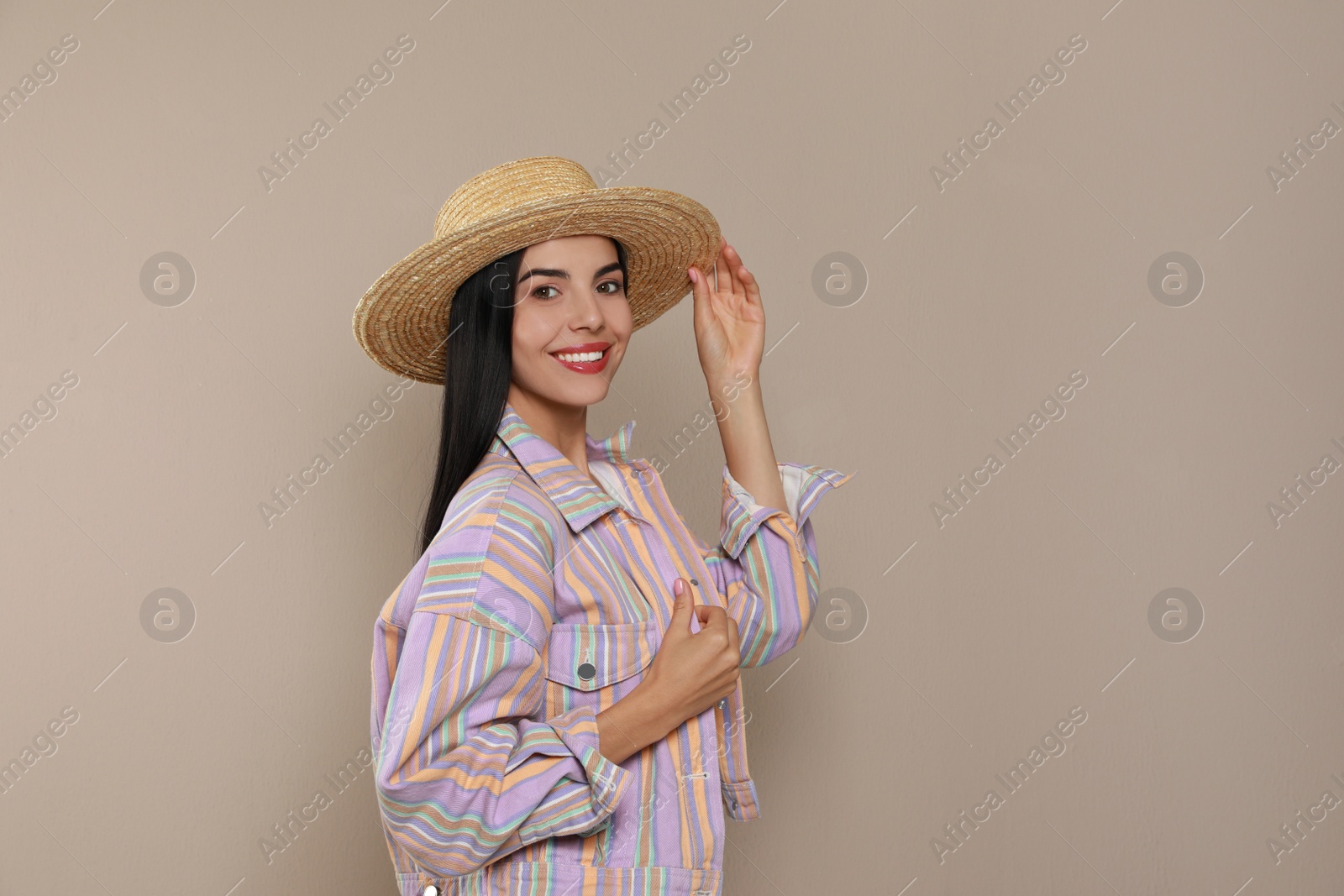 Photo of Beautiful young woman with straw hat on beige background