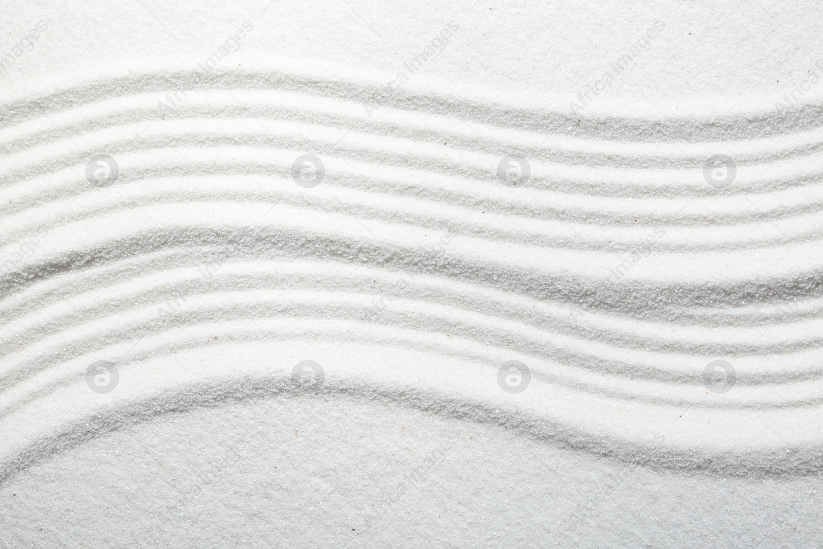 Photo of Zen rock garden. Wave pattern on white sand, top view