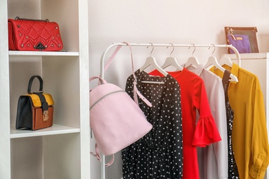 Photo of Wardrobe with stylish bags and clothes indoors. Idea for interior design