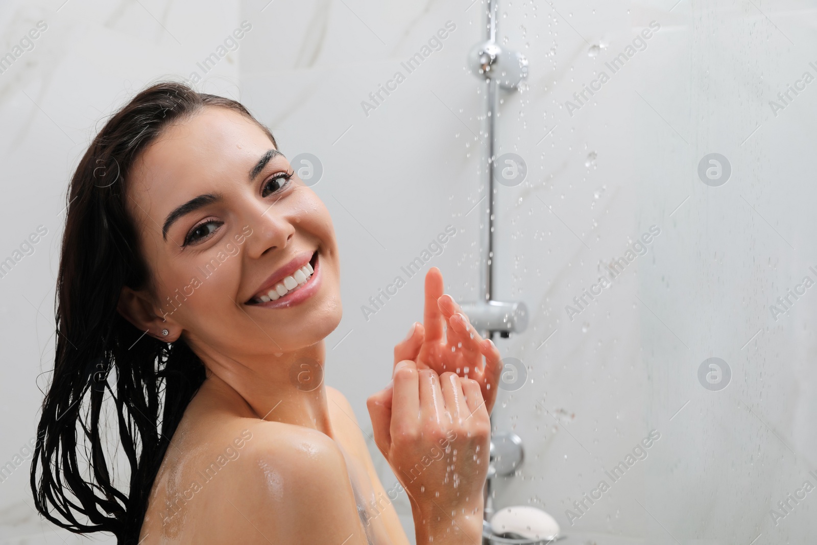 Photo of Beautiful young woman taking shower at home. Space for text