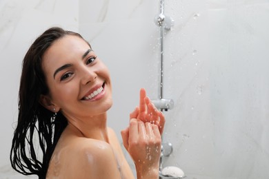 Photo of Beautiful young woman taking shower at home. Space for text