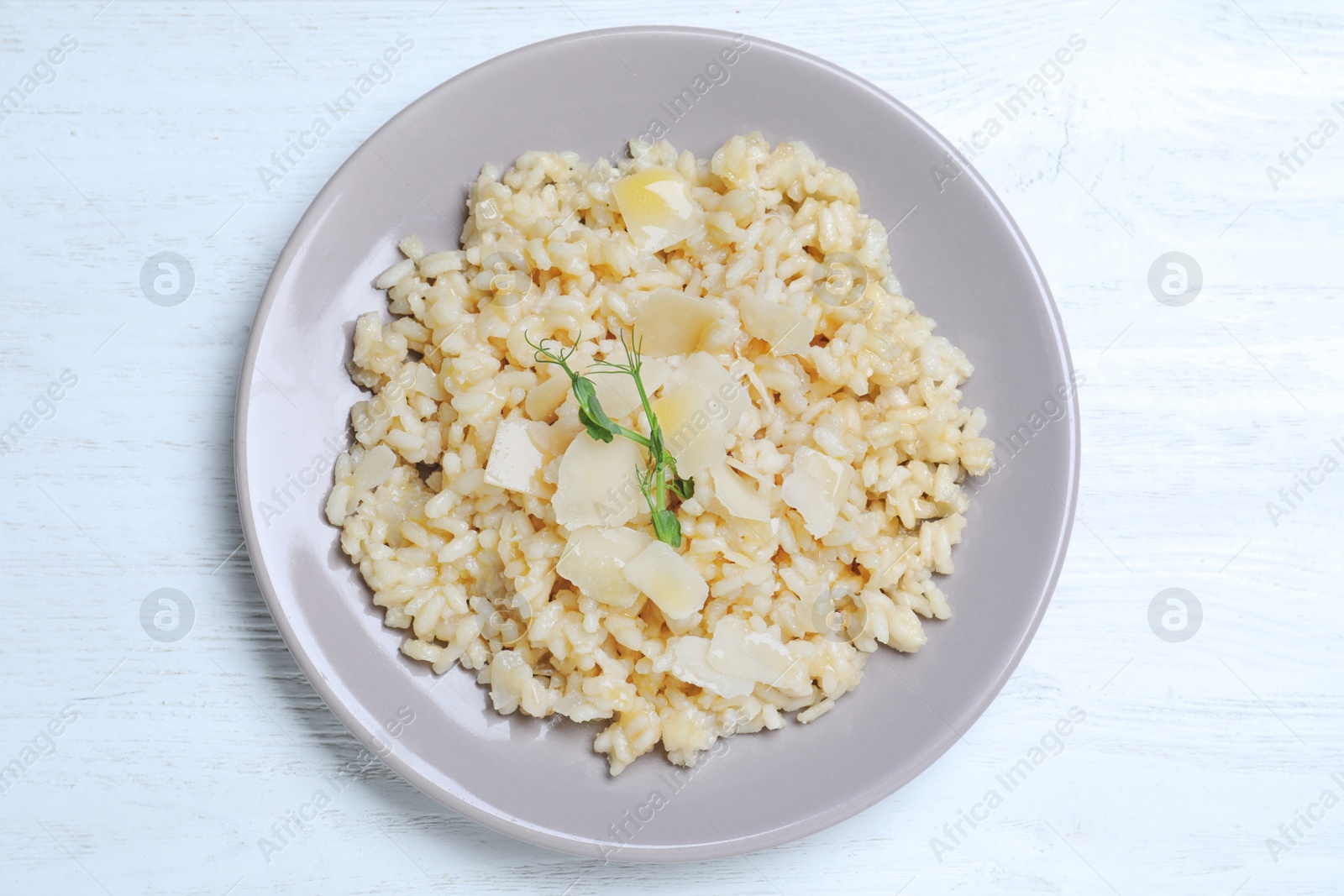 Photo of Delicious risotto with cheese on white wooden table, top view