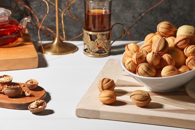Photo of Aromatic walnut shaped cookies and tea on white table. Homemade pastry carrying nostalgic atmosphere