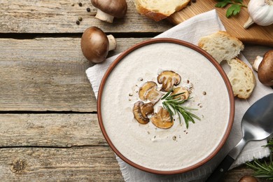 Fresh homemade mushroom soup served on wooden table, flat lay. Space for text