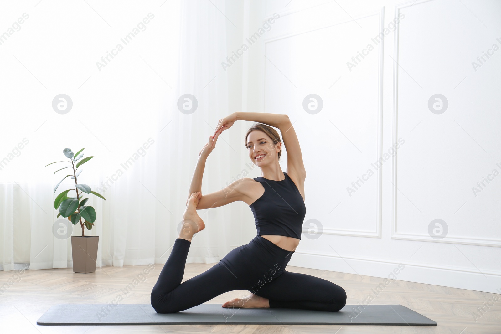 Photo of Young woman practicing mermaid asana in yoga studio. Eka Pada Rajakapotasana pose