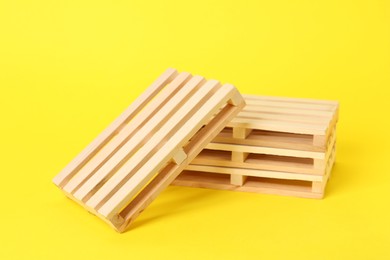 Many small wooden pallets on yellow background