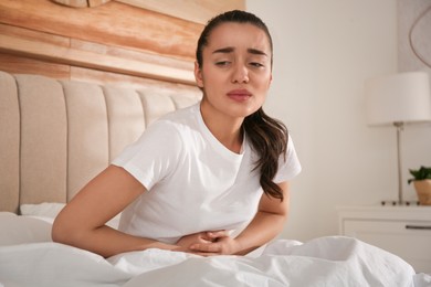 Photo of Young woman suffering from stomach ache at home. Food poisoning]