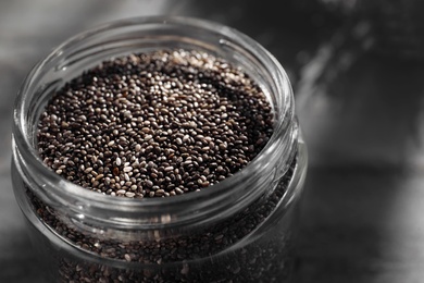 Glass jar with chia seeds on table, closeup