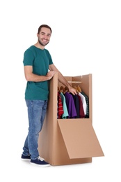 Photo of Young man near wardrobe box on white background