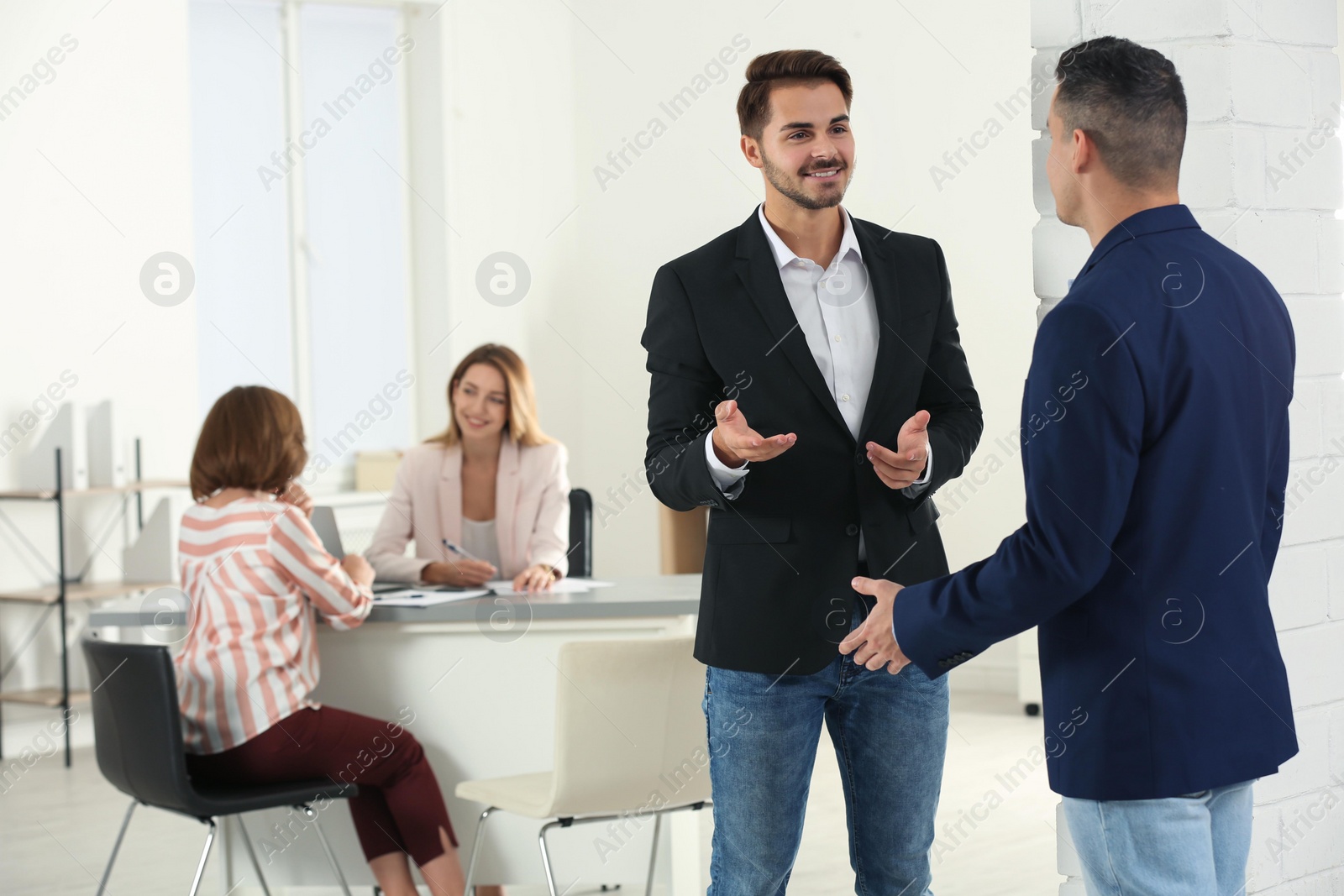 Photo of Human resources manager speaking with applicant before job interview in office