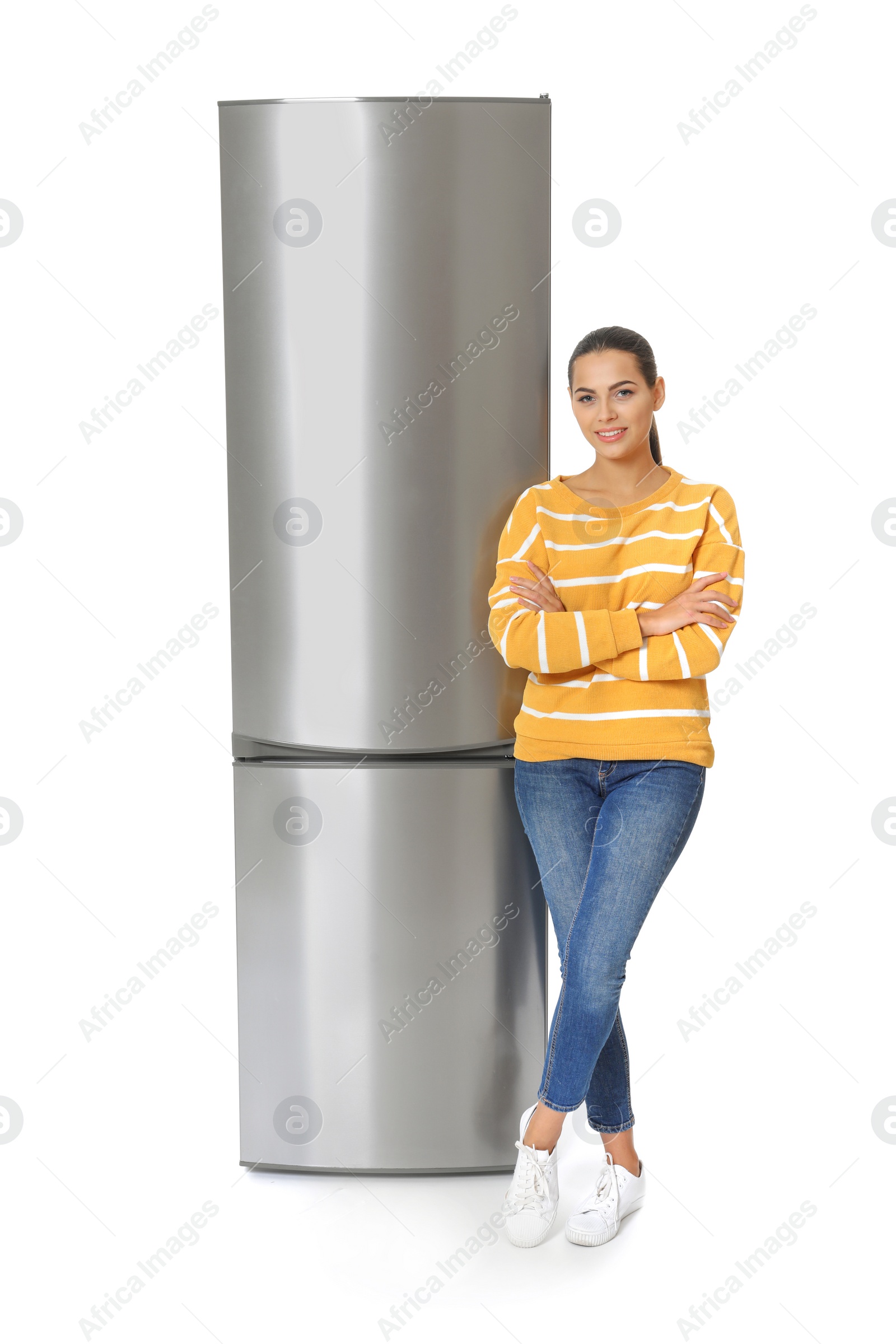 Photo of Young woman near closed refrigerator on white background