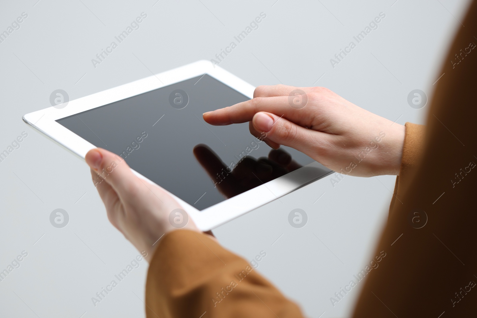 Photo of Closeup view of woman using modern tablet on light grey background