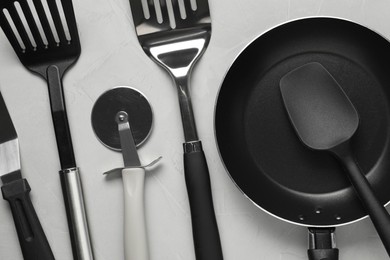 Photo of Different spatulas and other kitchen utensils on grey background, flat lay