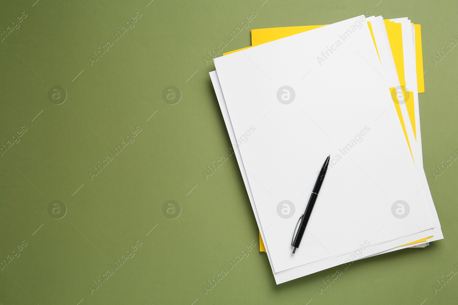 Photo of Yellow files with blank sheets of paper and pen on olive background, top view. Space for text