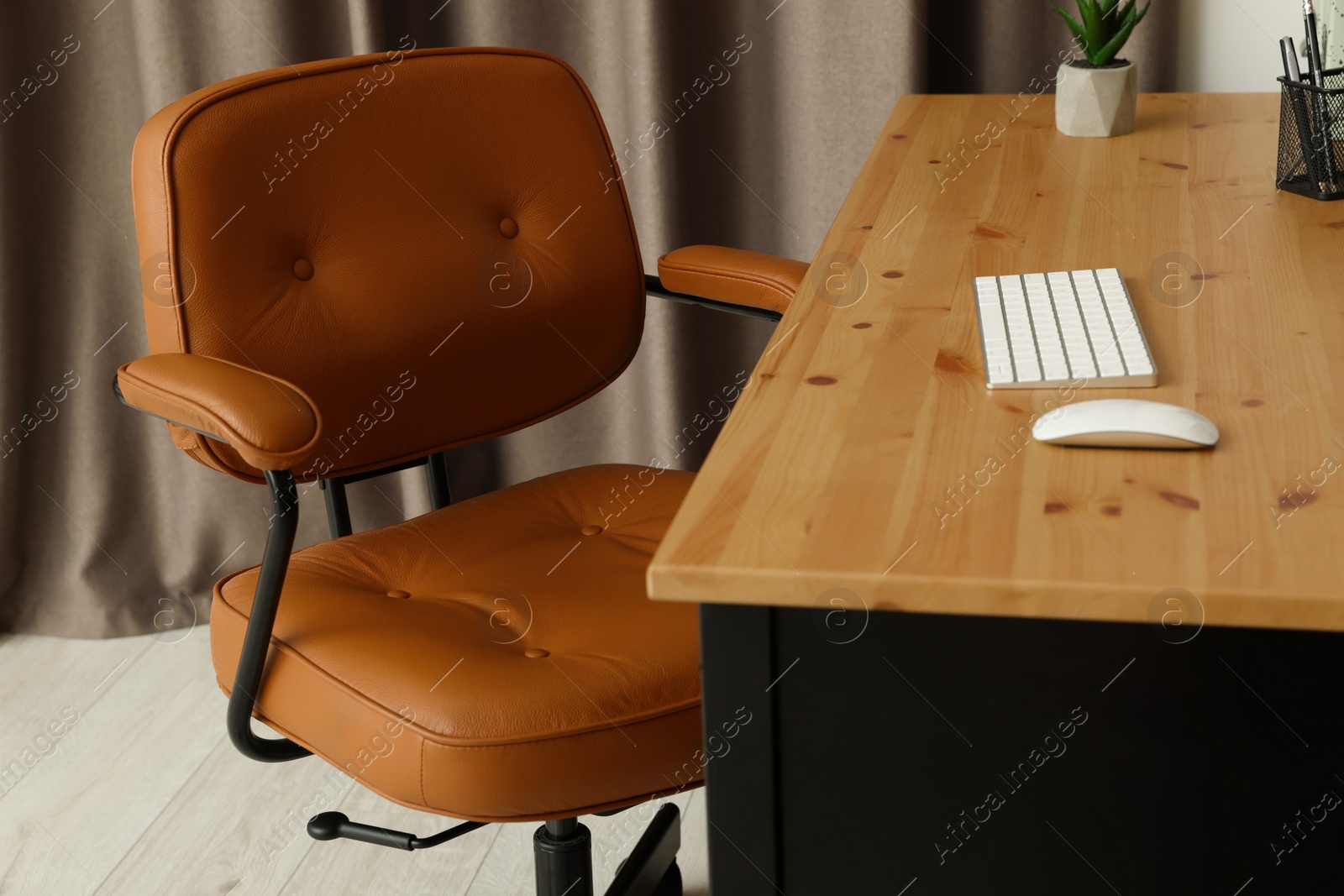 Photo of Comfortable office chair near desk at workplace