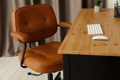 Comfortable office chair near desk at workplace