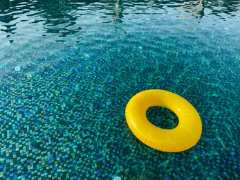 Yellow inflatable ring in swimming pool outdoors