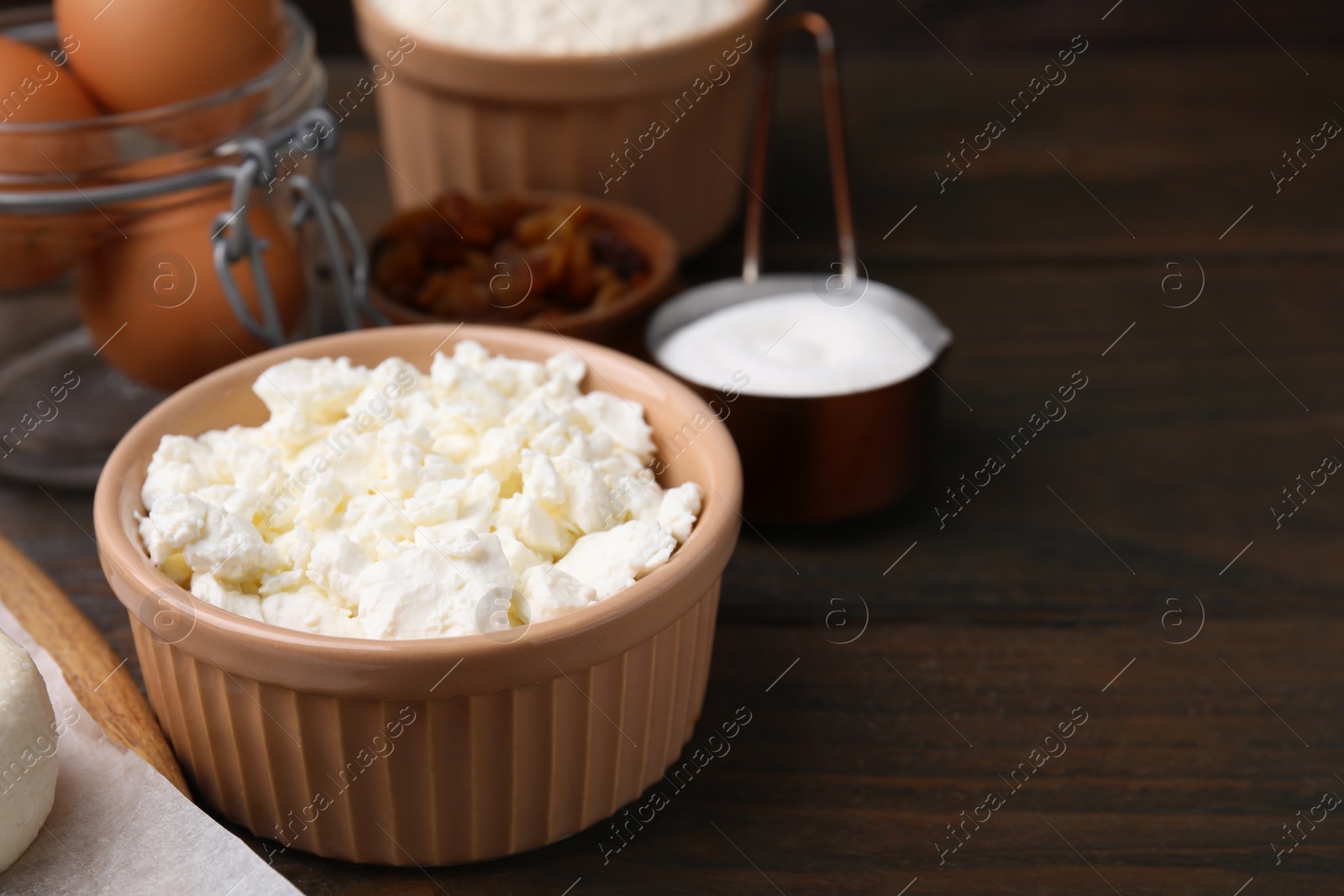 Photo of Different ingredients on wooden table, space for text. Cooking cottage cheese pancakes
