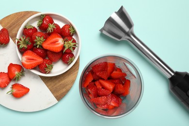 Photo of Hand blender kit and fresh strawberries on turquoise background, flat lay