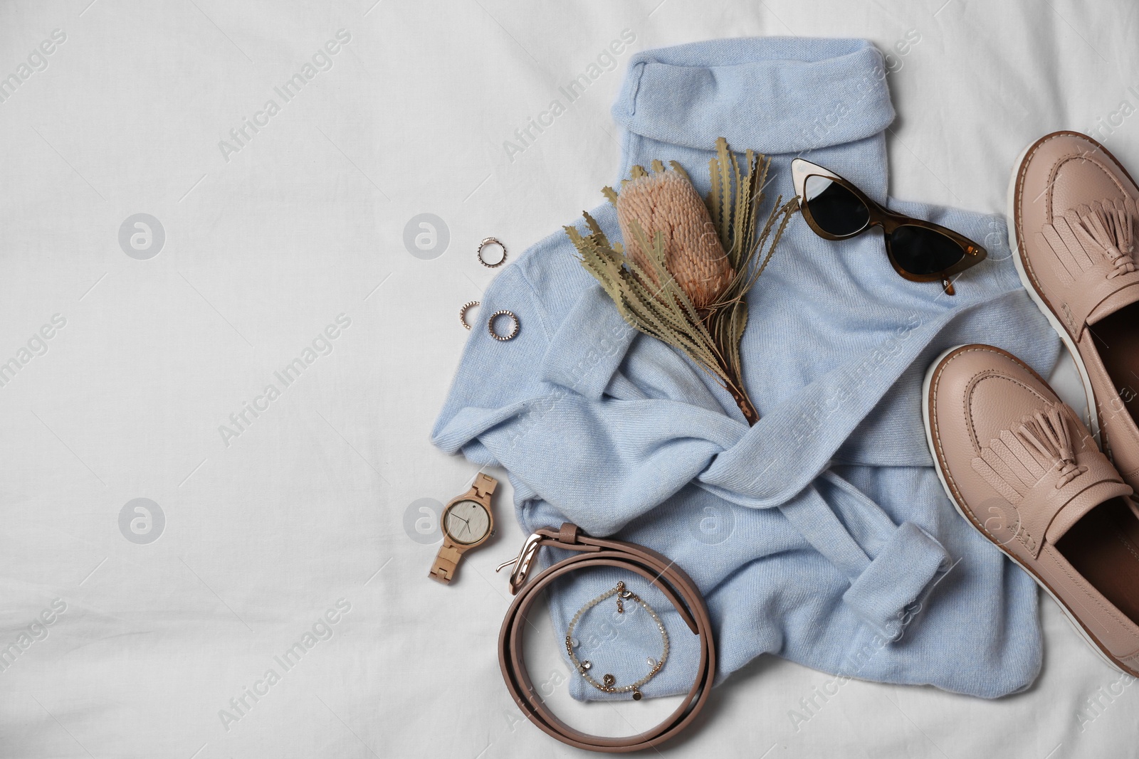 Photo of Stylish look with cashmere sweater, flat lay. Women's clothes and accessories on fabric