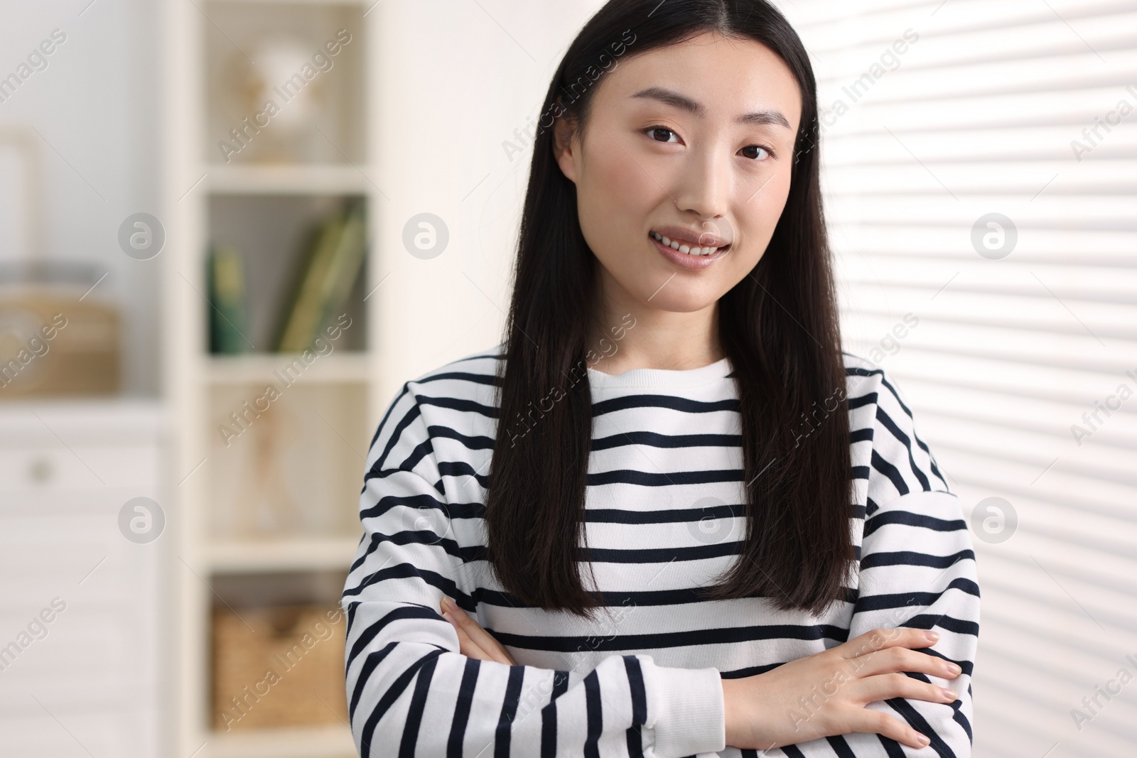 Photo of Portrait of smiling businesswoman with crossed arms in office