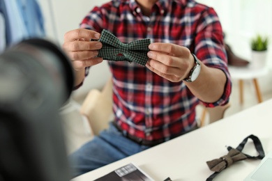 Photo of Fashion blogger with bow tie recording video on camera at home