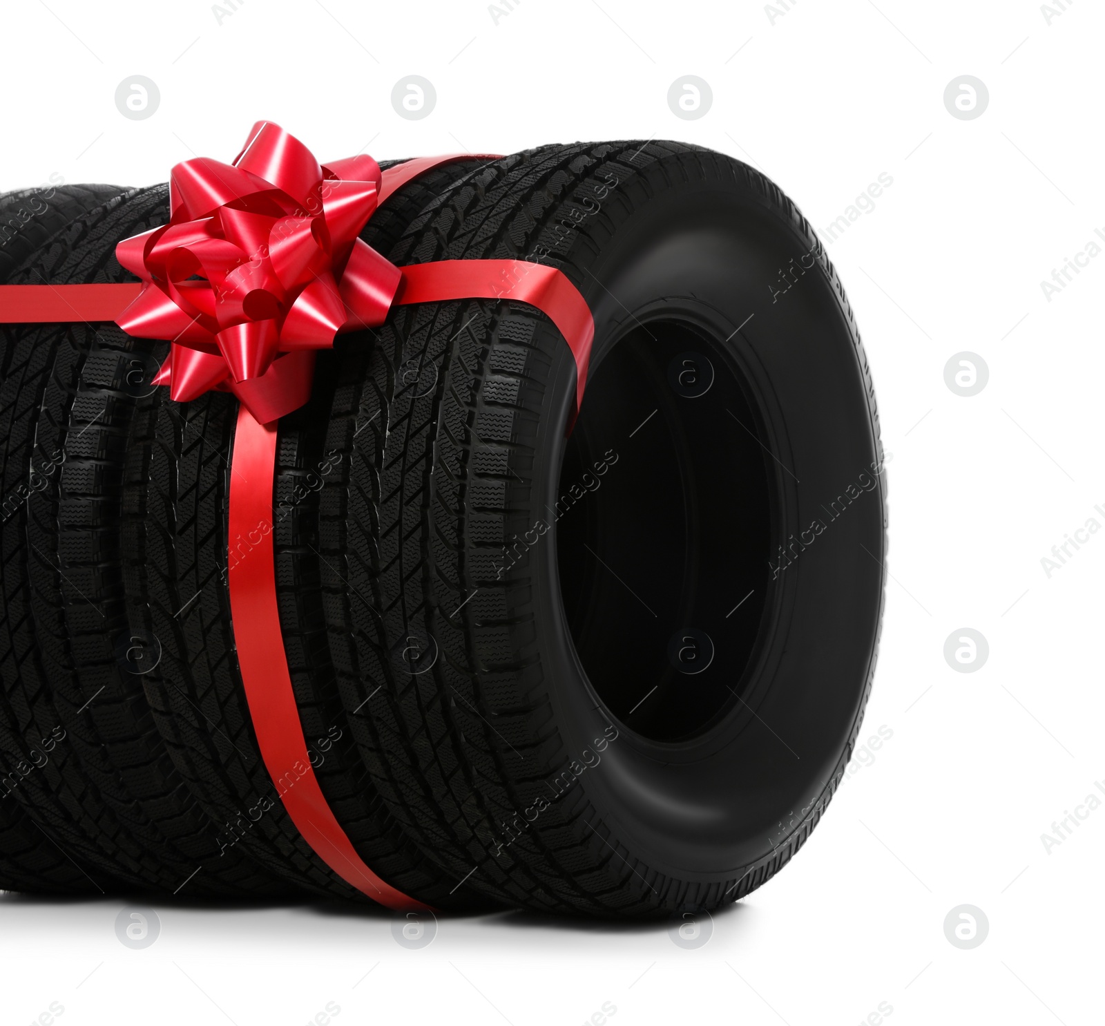 Photo of Winter tires with red ribbon on white background