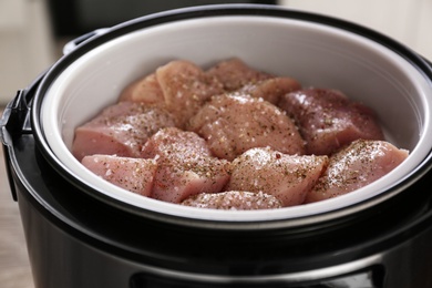 Photo of Delicious fresh chicken with spices in modern multi cooker, closeup