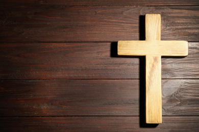 Photo of Christian cross on wooden background, top view with space for text. Religion concept
