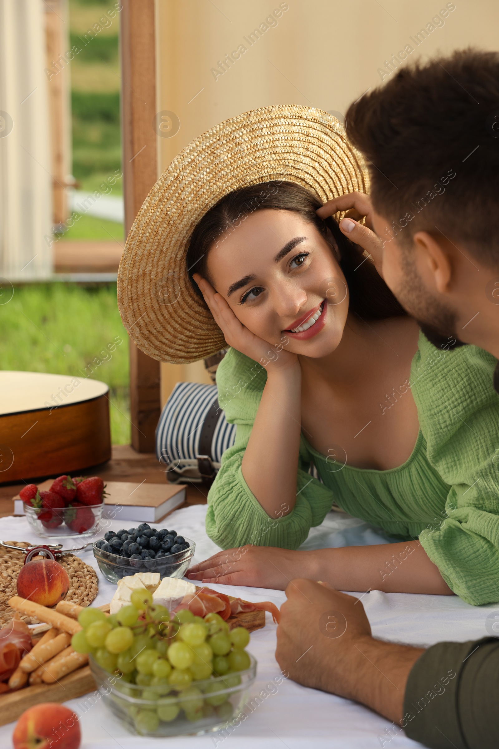 Photo of Romantic date. Beautiful couple spending time together during picnic in wooden gazebo