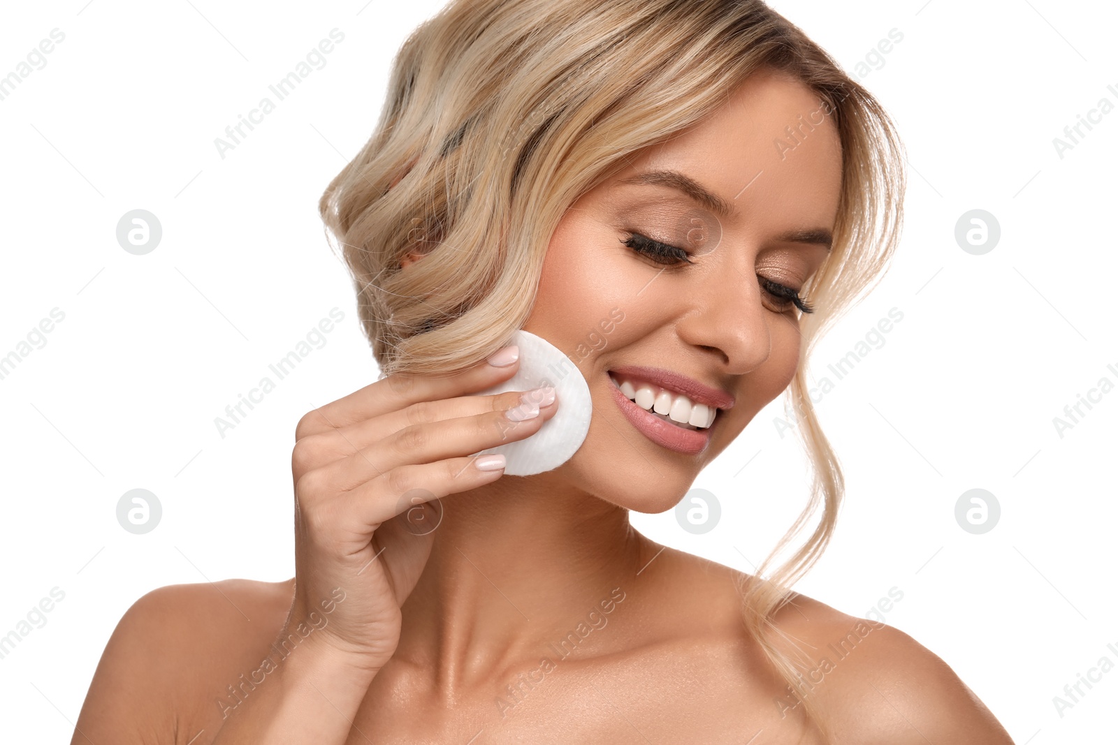 Photo of Smiling woman removing makeup with cotton pad on white background