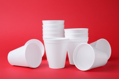 Many white styrofoam cups on red background