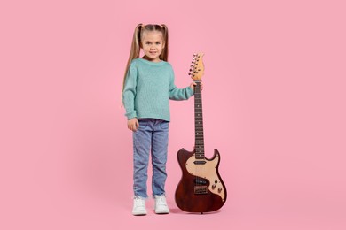 Photo of Happy girl with electric guitar on pink background