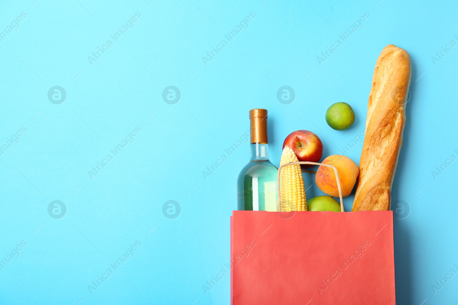 Photo of Flat lay composition with shopping bag and products on color background