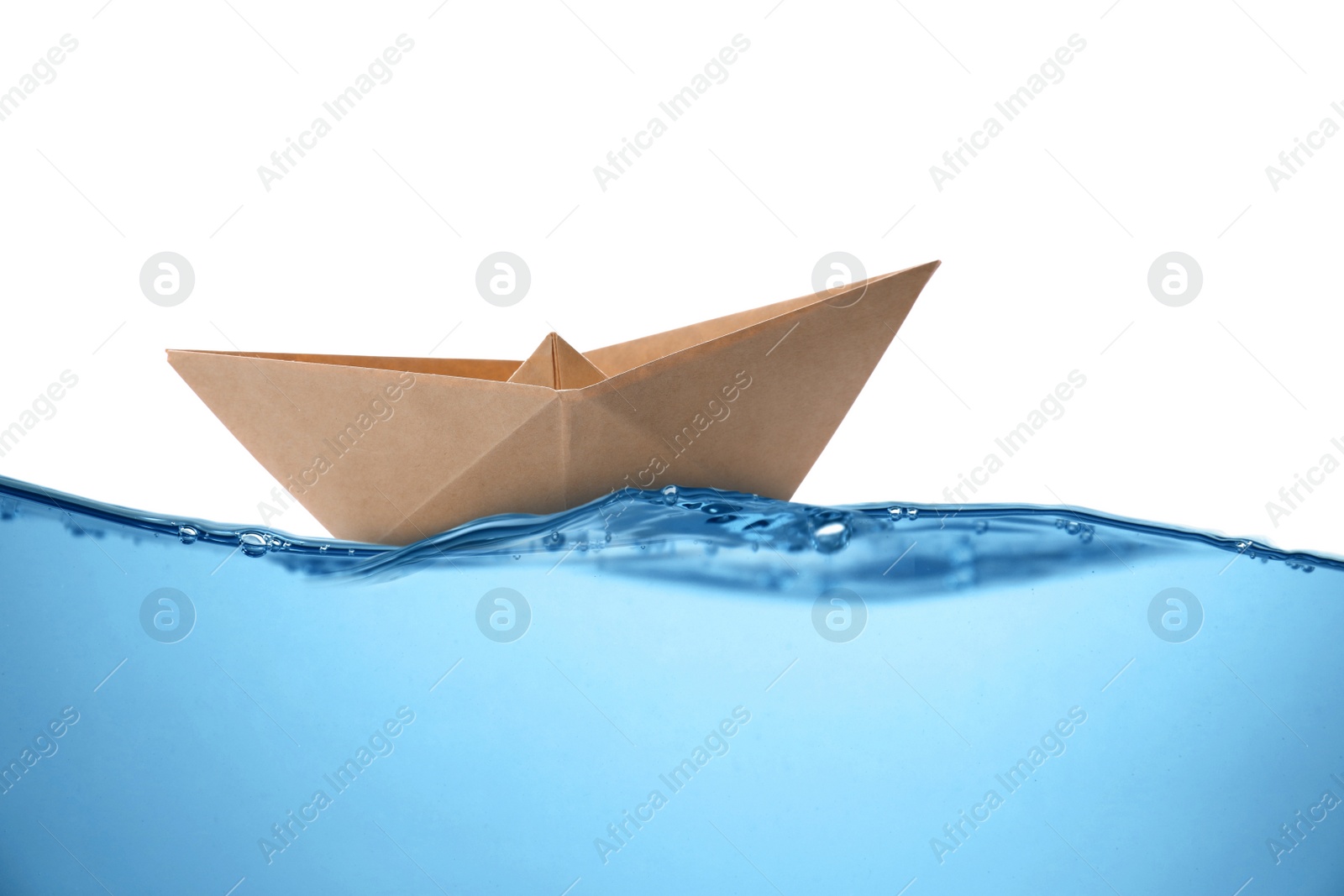 Image of Handmade kraft paper boat floating on clear water against white background 