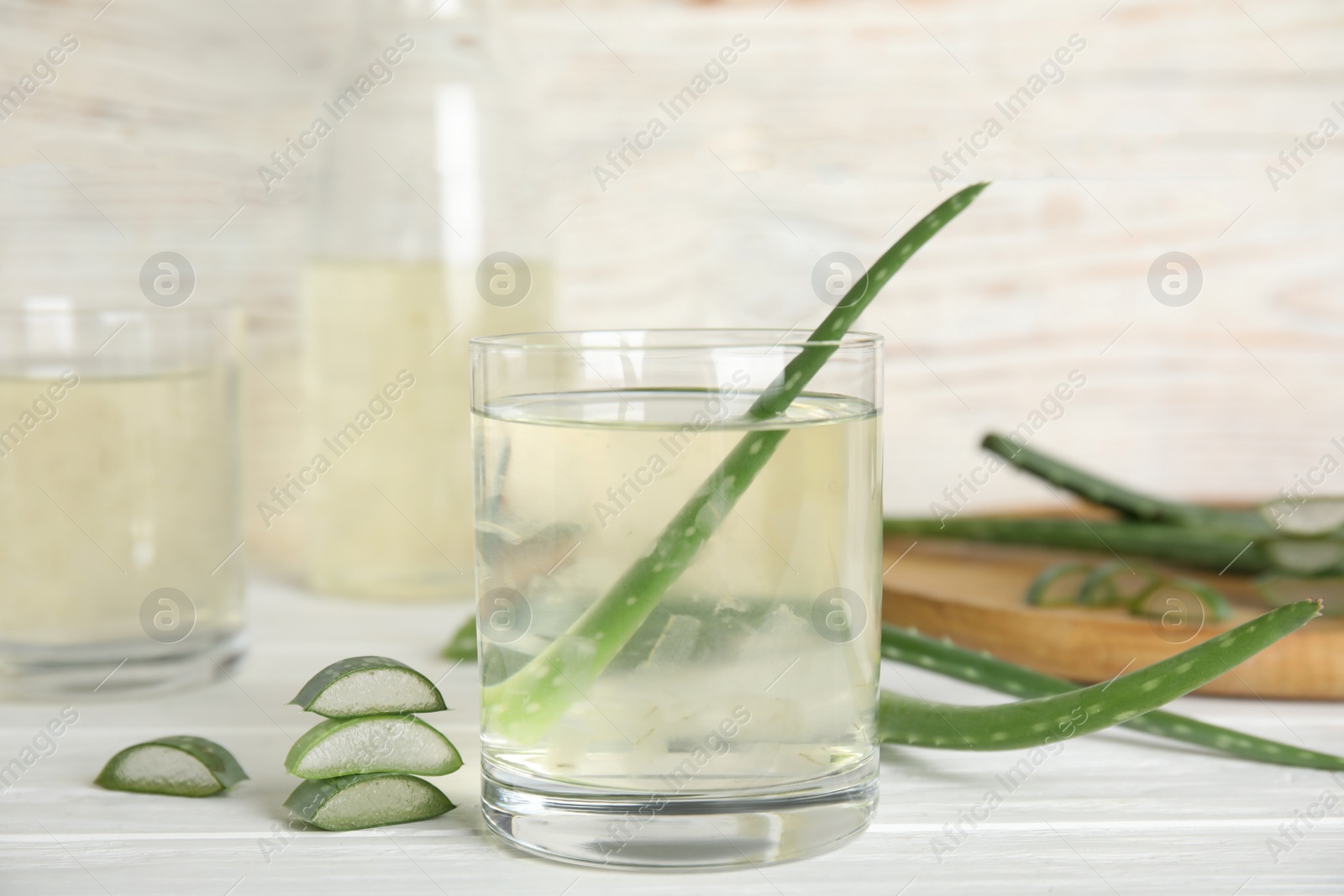 Photo of Fresh aloe drink on light wooden table, closeup