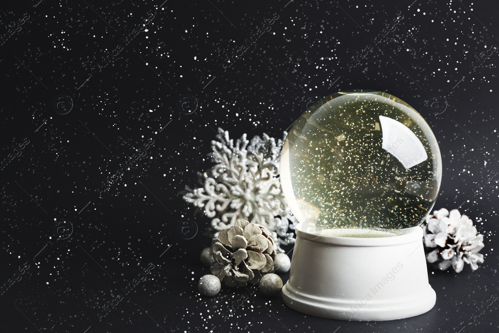 Image of Beautiful snow globe and Christmas decorations on dark grey background. Space for text