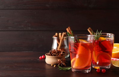 Photo of Aromatic punch drink and ingredients on wooden table. Space for text