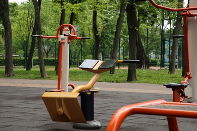 Photo of Empty outdoor gym with back extensioner, twister and surfer