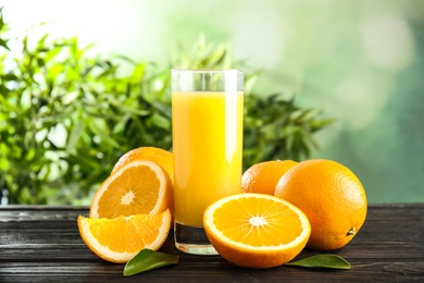 Glass with orange juice and fresh fruit on wooden table