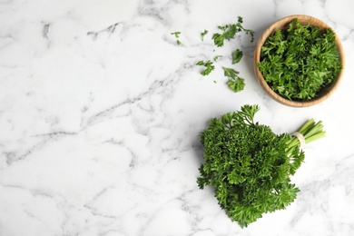 Photo of Flat lay composition with fresh green parsley on marble table, space for text