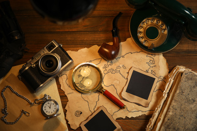 Flat lay composition with vintage detective items on wooden table